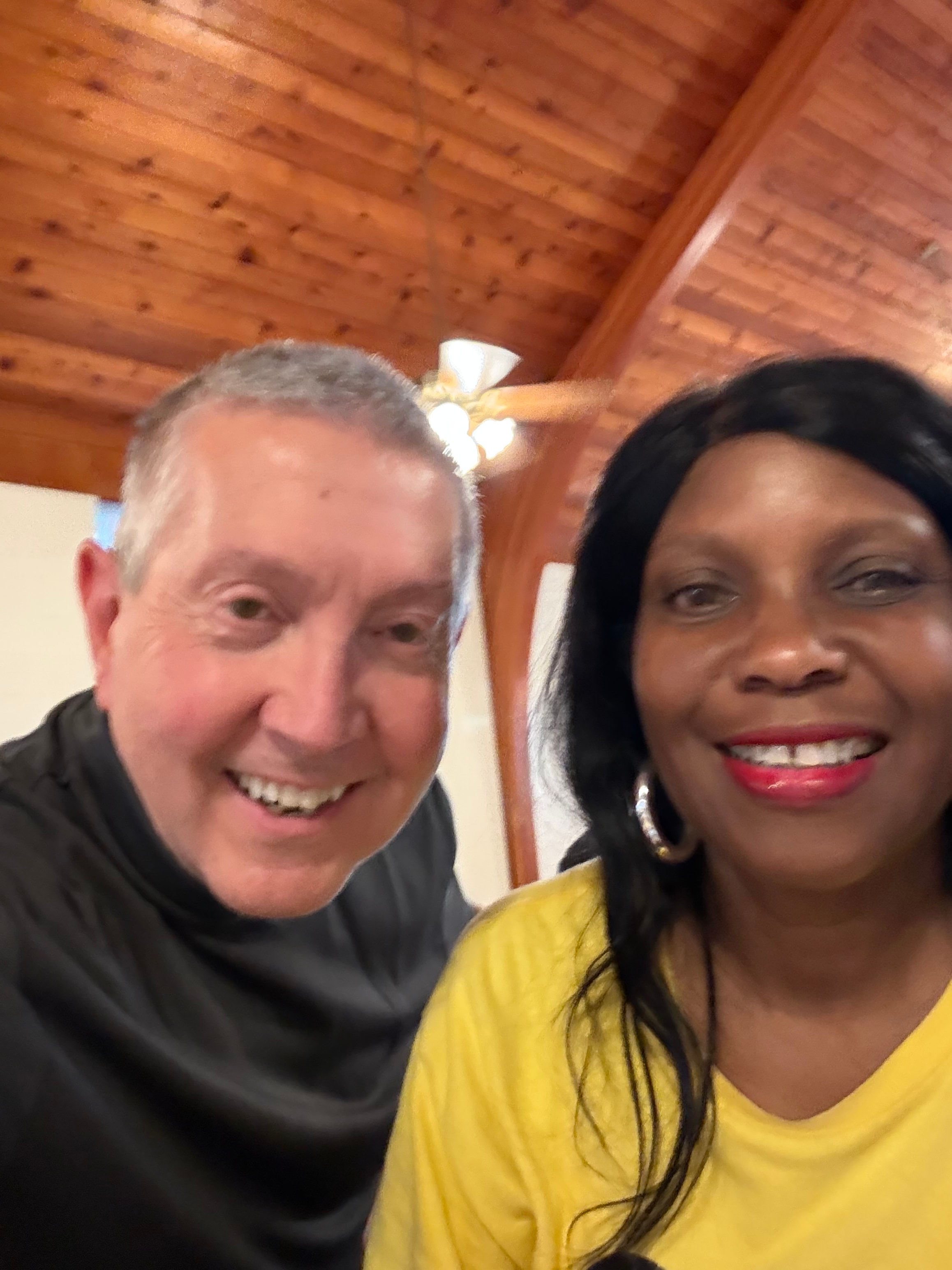 Two Kids R Cookin' volunteers smiling together in the parish hall